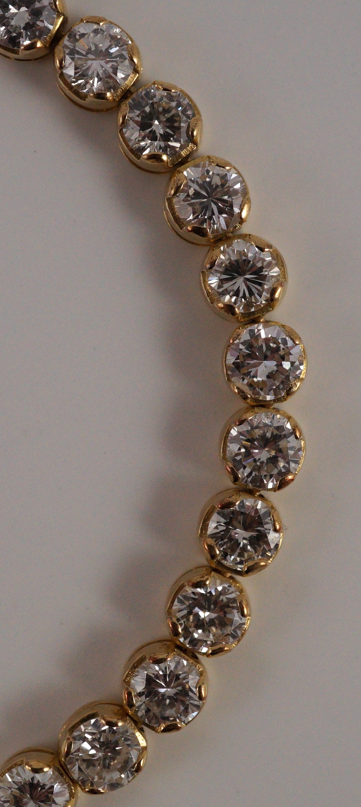 A modern 18k gold and round brilliant cut diamond set line bracelet